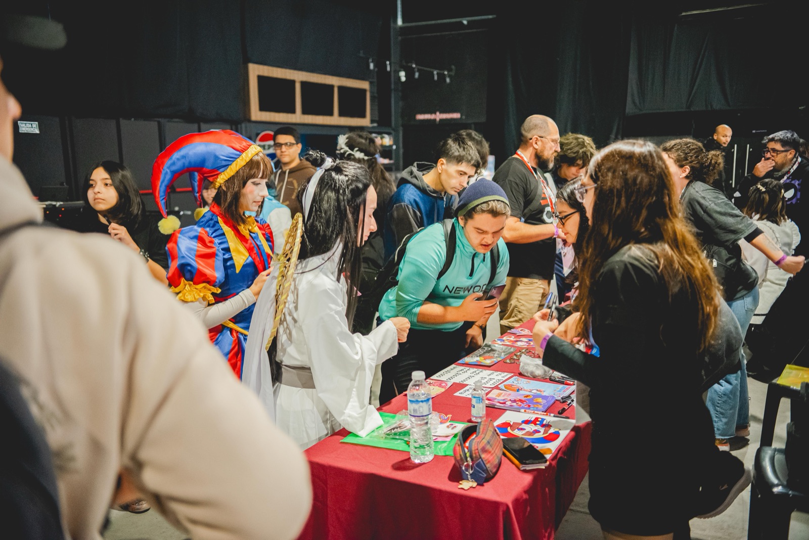 Mesa del Artist Alley con cosplayers y público